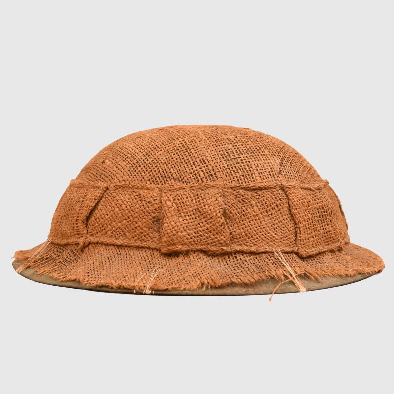 BRITISH WWI 1ST PATTERN BRODIE HELMET WITH A RARE TYPE OF SACKING COVER.