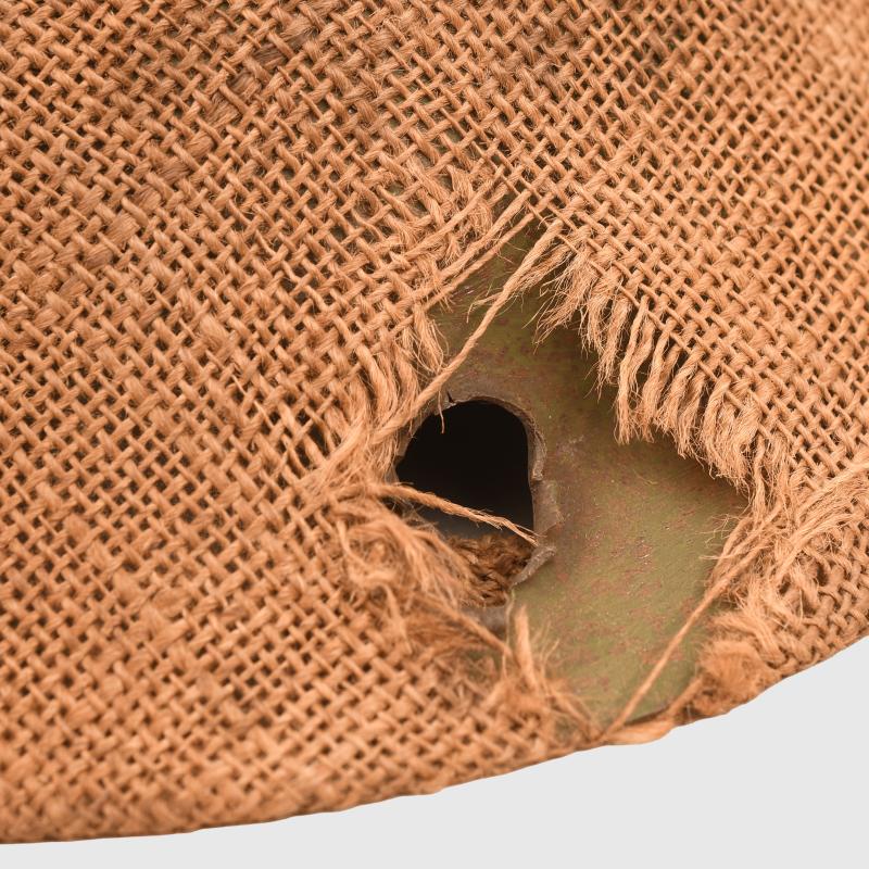 BRITISH WWI VERY FIRST PATTERN BRODIE HELMET IN GREEN WITH BATTLE DAMAGE AND FIELD COVER.