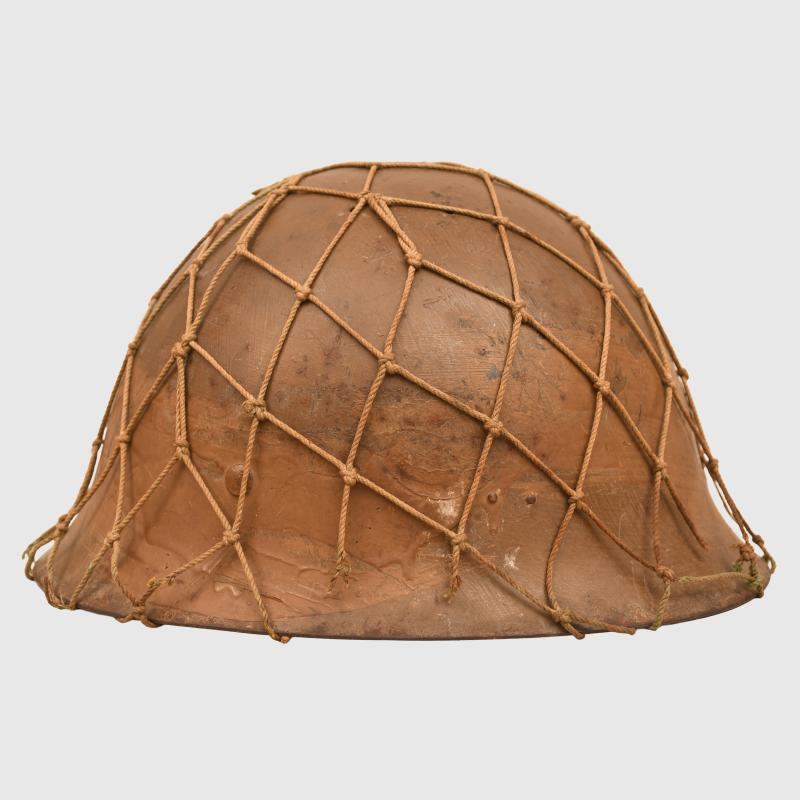 JAPANESE WWII TYPE 90 COMBAT HELMET WITH CAMOUFLAGE NET, IDENTIFIED TO AN INDIVIDUAL SOLDIER.
